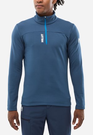 Pull-over en polaire bleu avec un col haut et une fermeture éclair quart. Présente un logo blanc et une fermeture éclair bleu contrastant. Texture lisse et design ajusté.