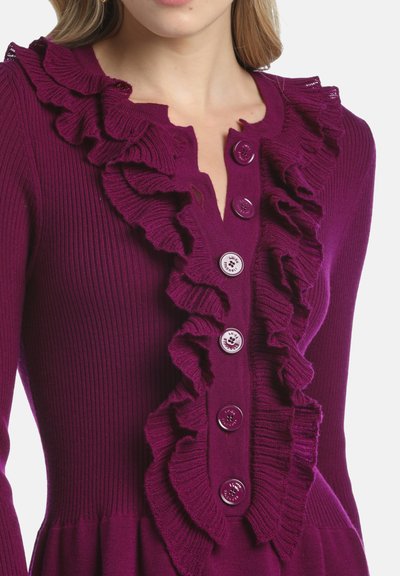 Fuchsia ribbad stickad cardigan med en volangdesign framtill och fem stora knappar. Tyget har en mjuk textur med en figurnära silhuett.