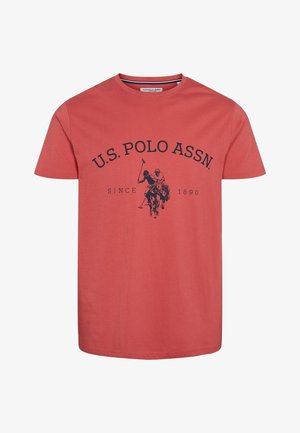 Koraalrode T-shirt met korte mouwen, met zwarte tekst 'U.S. Polo Assn.' en logo van twee polo rijders te paard, en de tekst 'Since 1890'.