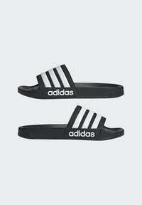 Svarta flip-flop sandaler med tre vita ränder och "adidas" logotyp. Tillverkade av syntetmaterial med platt sula och öppen tå-design.