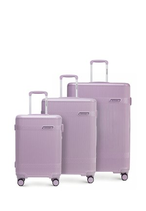 Three pastel purple hard-shell suitcases with vertical ridges, telescoping handles, and four rotating wheels, arranged by size from small to large.
