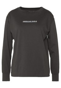 Tričko s dlouhým rukávem v tmavě šedé barvě z bavlny, s kulatým výstřihem a bílým nápisem "AMERICAN EAGLE" umístěným na hrudi. Jednoduchý design.