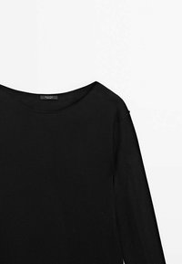 Chemise noire à manches longues avec un large col rond affichée sur fond blanc.