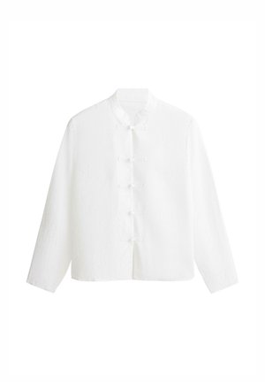 Camicia bianca a maniche lunghe con colletto alla coreana e chiusure tradizionali cinesi con bottoni a forma di rana sul davanti.