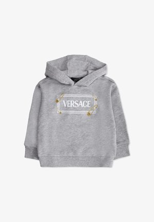 Felpa grigia con cappuccio e grafica frontale che presenta la scritta "VERSACE," abbellita da spille di sicurezza dorate e un bordo a scacchi. Tessuto morbido.