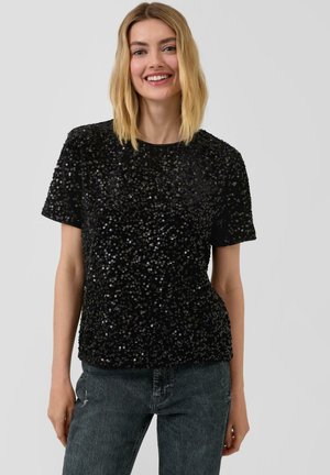 Zwarte pailletten top met korte mouwen en ronde halslijn, voorzien van een gestructureerd oppervlak en een aansluitende silhouet, gecombineerd met donkergrijze spijkerbroek.