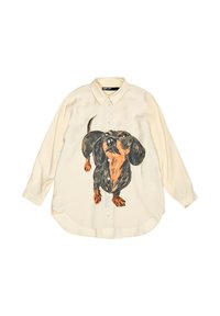 Camisa de corte holgado en color crema con diseño pintado de un dachshund negro y marrón, cierre delantero de botones y mangas largas con dobladillo redondeado. Tejido texturizado.