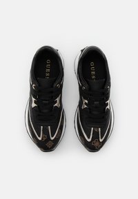 Schwarze Sneaker mit metallischen Akzenten, ausgestattet mit einem texturierten Muster und Schnürsenkeln, runder Form und einem Logo auf der Innensohle.