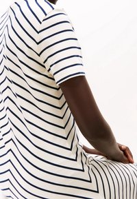 Vit och marinblå randig kortärmad topp med rund halsringning och subtil textur. Har en klassisk passform och mjukt bomullsmaterial.