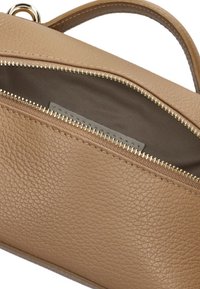 Beige Lederhandtasche mit strukturierter Oberfläche, ausgestattet mit einem goldenen Reißverschluss und einem mit Stoff gefütterten Innenraum. Das Design beinhaltet einen kurzen Griff.