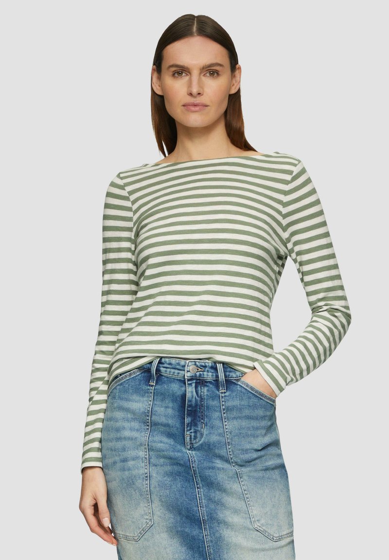 Grün-weiß gestreiftes Langarmshirt mit Bootsausschnitt, aus weichem Stoff. Kombiniert mit einem Jeansrock, der einen leichten Farbverlauf aufweist.