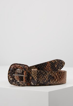 Ruskea ja musta käärmekuvioitu nahkavyö, jossa on siihen sopiva pyöreä solki, lepää valkoisella pinnalla.