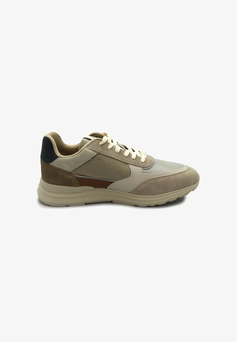 Zapatilla beige que presenta una combinación de texturas lisas y de ante, con acentos en marrón claro y suela de goma. Diseño con cordones y cuello acolchado.