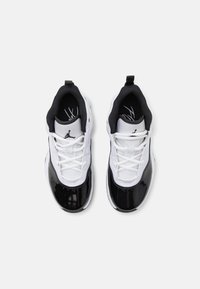 Baskets blanches et noires avec une finition en cuir verni brillant, tige en maille texturée et lacets contrastants avec un logo sur la languette.