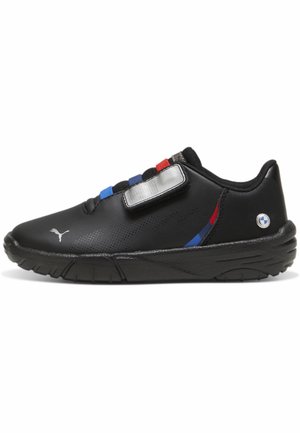 Zwarte Puma-sneaker met rode, blauwe en zwarte elastische banden, een zilveren klittenbandsluiting en BMW-logo op de hiel, zijaanzicht tegen een witte achtergrond.