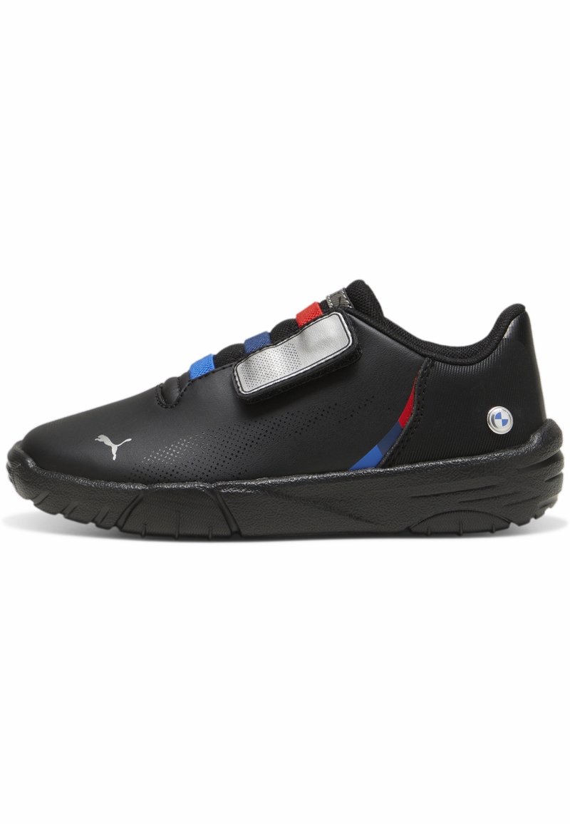 Baskets Puma noires avec des bandes élastiques rouges, bleues et noires, une bande Velcro argentée, et le logo BMW sur le talon, vue de côté sur fond blanc.