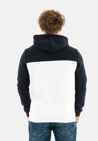 Felpa con cappuccio con la parte superiore blu navy e la parte inferiore bianca. Presenta maniche lunghe, una tasca a marsupio e un tessuto strutturato.