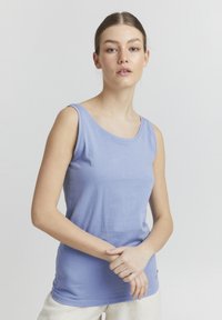 Világoskék tank top, puha, sima anyagból készült. Kerek nyakkivágással és széles vállpántokkal rendelkezik. Egyszerű dizájn, minta vagy díszítés nélkül.