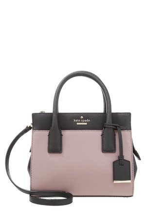 Petit sac à main Kate Spade avec poignées noires, bandoulière et bordure supérieure sur un corps mauve, avec une étiquette suspendue et un logo doré.