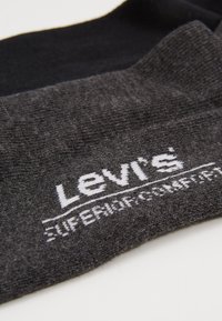 Dva páry ponožiek v čiernej a antracitovo sivej farbe, s jemnou textúrou a bielym logom "Levi's" so slovami "SUPERIOR COMFORT".
