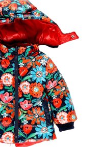 Gevoerde winterjas met een bloemmotief in levendig rood, oranje en blauw op een donkere achtergrond; voorzien van een rode voering en capuchon.