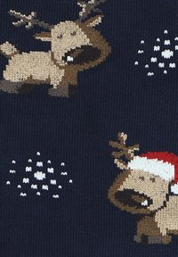 Granatowy dzianinowy materiał z motywem reniferów w jasnobrązowym i beżowym kolorze, noszących czerwone czapki Mikołaja, w towarzystwie białych wzorów płatków śniegu.