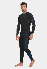 Czarna pianka nurkowa z niebieskimi akcentami, teksturowany design, długie rękawy, dopasowany krój, podkreślający atletyczną sylwetkę. Materiał wygląda na elastyczny i trwały.