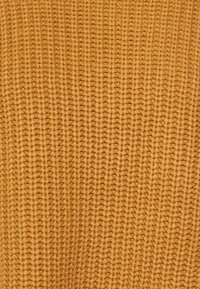 Tissu tricoté jaune moutarde chaud avec un motif texturé, comprenant des rangées surélevées qui créent une apparence chaleureuse.