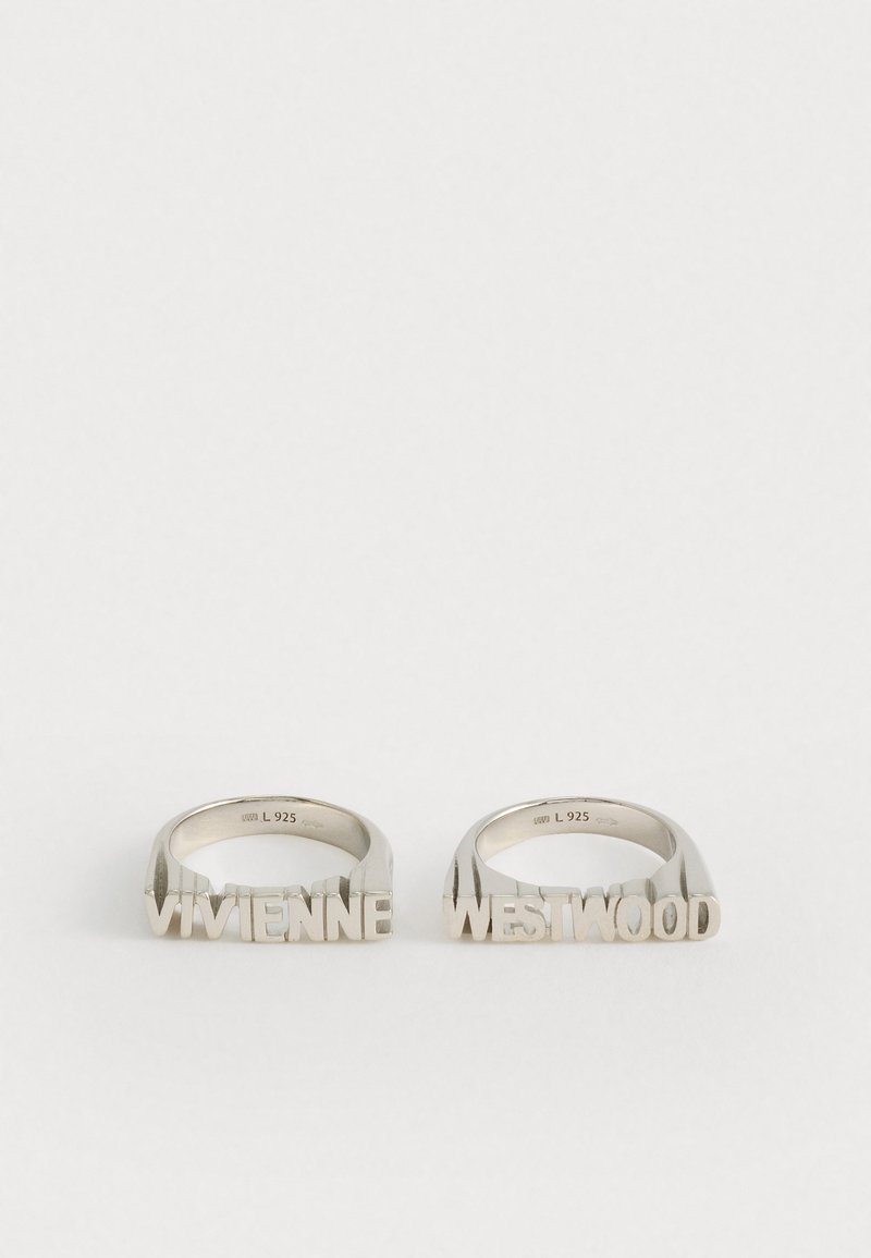 Két ezüst gyűrű, amelyek blokkbetűkkel írják a "VIVIENNE" és "WESTWOOD" szavakat, mindkét gyűrű belsejében "L 925" felirattal.