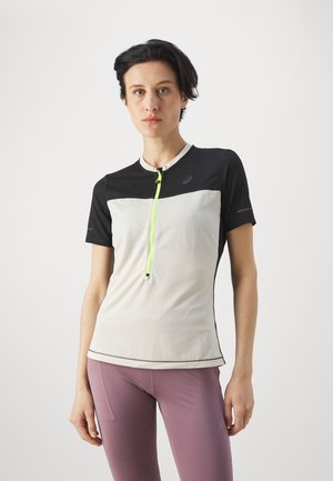 Camiseta deportiva de manga corta en negro y blanco con una cremallera de color amarillo neón, que presenta un patrón texturizado y un diseño ajustado.