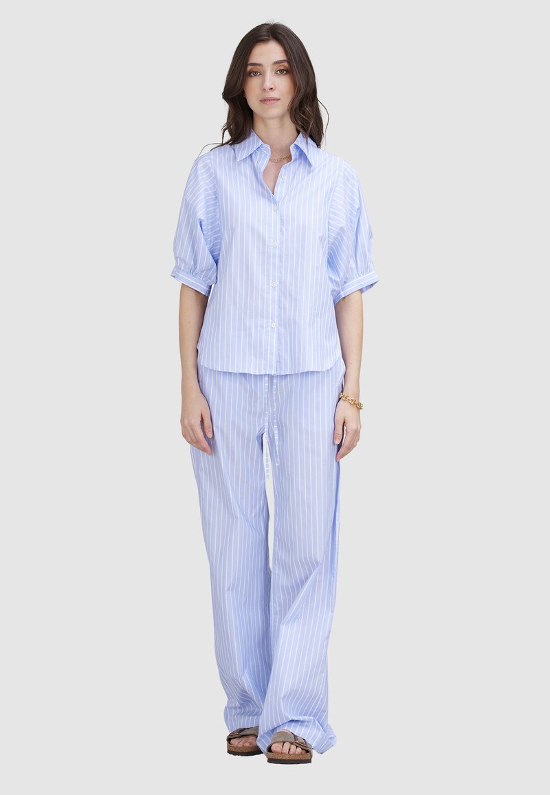 Hellblau gestreiftes Hemd mit kurzen Ärmeln, kombiniert mit passenden weit geschnittenen Hosen. Beide Teile haben eine glatte Textur und einen lockeren Sitz.