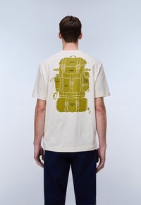 Κρεμ βαμβακερό t-shirt με ελιά πράσινο σχέδιο ενός σακιδίου και εξοπλισμού κάμπινγκ στην πλάτη. Κοντά μανίκια, άνετη εφαρμογή.