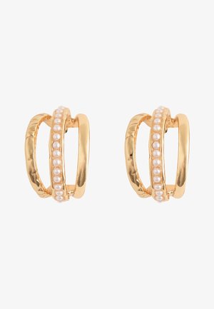 Paar goldfarbene Ohrringe mit dreifachem Kreisdessin, ein Ring mit kleinen weißen Perlen entlang des mittleren Bandes.