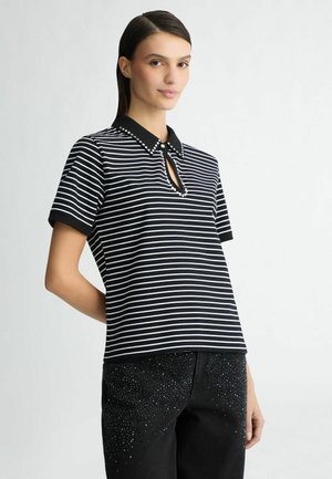 Zwart-wit gestreepte polo met een keyhole-opening, een effen zwarte kraag en decoratieve studs langs de halslijn.