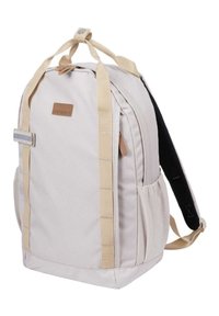Vaaleanbeige kankainen reppu ruskeilla yksityiskohdilla, vetskari suljenta, pehmustetut hihnat ja sivutaskut. Ominaisuuksiin kuuluu suorakulmainen muoto ja vahvistettu kahva.