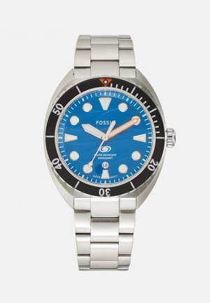 Montre Fossil en acier inoxydable avec un cadran bleu, une lunette noire, une aiguille des secondes orange et des marqueurs d'heure blancs. Étanche jusqu'à 200 mètres.