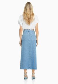 Ljusblå denim maxkjol med en slits bak, två bakfickor och en figursydd hög midja. Tillsammans med mintgröna klacksandaler.