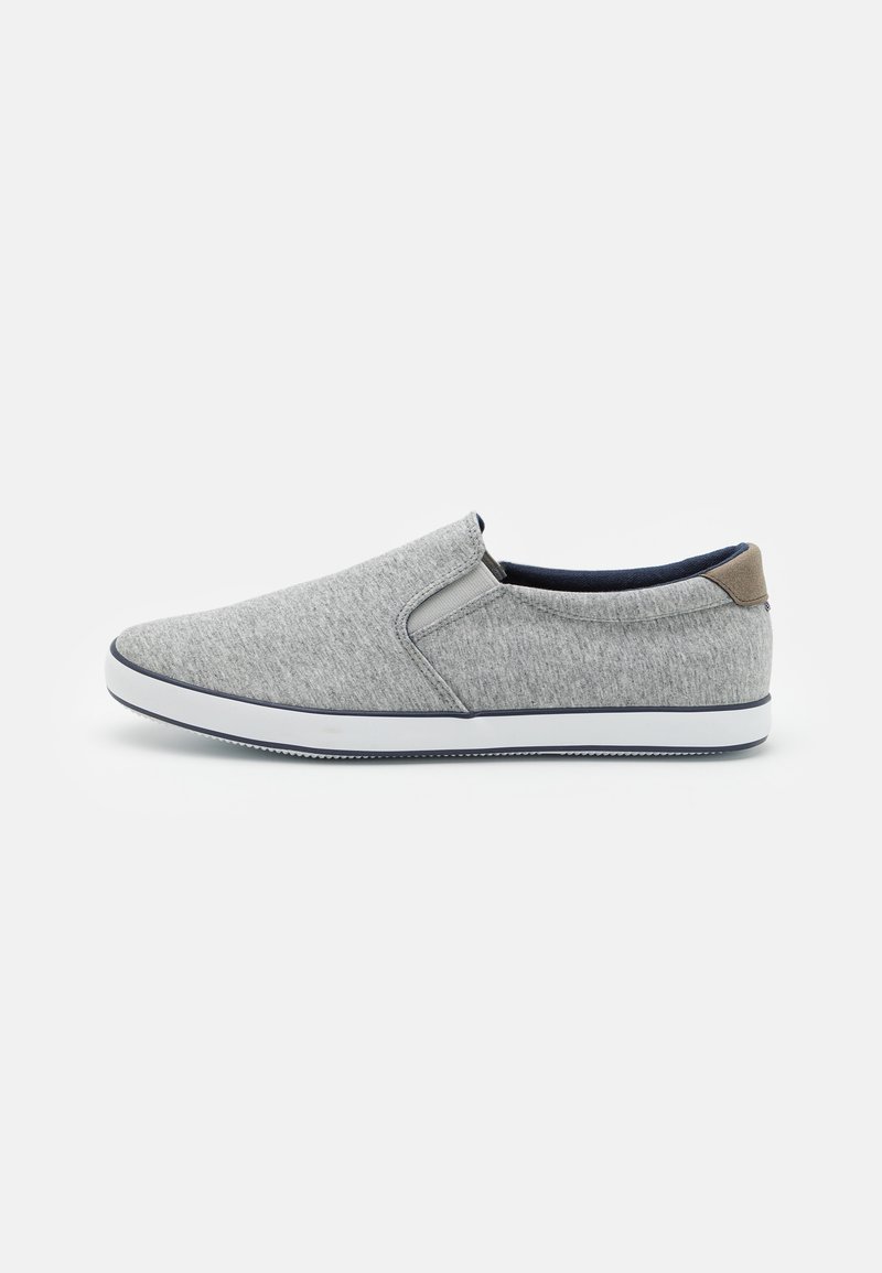 Szürke slip-on cipők, texturált anyagból, fehér gumitalppal és sötétkék béléssel. Barna hátsó díszítés. Áramvonalas kialakítás.