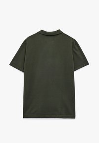 Oliivinvihreä polo-paita klassisella kauluksella, lyhyillä hihoilla ja suoraan helmalla. Tekstuuri vaikuttaa sileältä, tarjoten rentoa tyyliä.