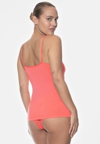 Koraliowy top na ramiączkach wykonany z gładkiego materiału, z cienkimi regulowanymi ramiączkami i dopasowanym krojem. Koronkowy detal na pasujących majtkach.