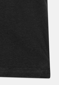 Juodas medvilnės t-shirt su lygiu paviršiumi, turintis tiesų apdailą ir trumpas rankoves. Nėra matomų raštų ar grafikų.