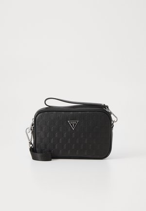 Černá texturová crossbody taška se zipovým uzávěrem, s výrazným trojúhelníkovým logem a nastavitelným popruhem. Odolný materiál s geometrickým vzorem.