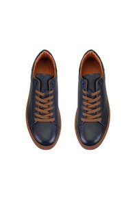 Marineblaue Leder-Sneaker mit einer strukturierten Oberseite, braunen Schnürsenkeln und einer kontrastierenden, sandfarbenen Sohle. Runde Zehenpartie mit minimalistischem Design.