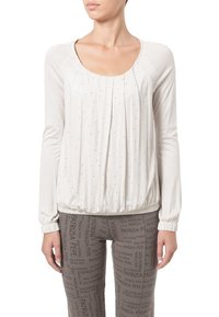 Helles beige Langarmoberteil mit gerafftem Saum, das dezente Falten und verstreute Strasssteine aufweist. Glattes Material mit lockerer Passform.