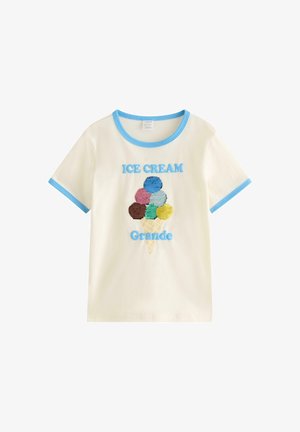 Kortærmet t-shirt i flødefarve med blå kant på krave og ærmer, der viser en isvaffel med seks farverige kugler og teksten "ICE CREAM Grande".