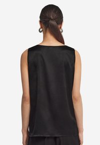 Svart satin ärmlös topp med rundad halsringning och slät textur. Designen är minimalistisk med rena kanter.