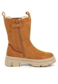 Botín de ante en tono marrón claro con cremallera lateral, suela de goma beige y detalles en burdeos a lo largo del costado. Dos tiradores para facilitar su uso.