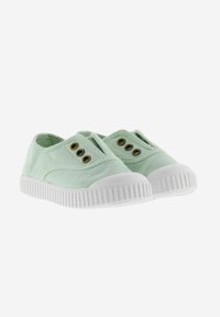Un paio di sneaker slip-on in tela verde chiaro con suole in gomma bianca e tre occhielli di bronzo ciascuno, posti su uno sfondo bianco.
