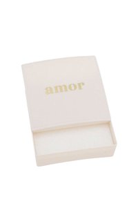 Scatola color crema con una texture liscia, testo "amor" in oro sul coperchio e un compartimento aperto che rivela un interno morbido e beige.