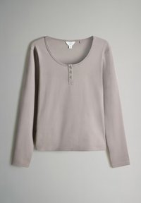 Langarmshirt aus leichtem Taubengrau-Baumwollstoff mit rundem Ausschnitt und drei Knöpfen auf der Vorderseite. Flache Nähte und keine sichtbaren Muster.